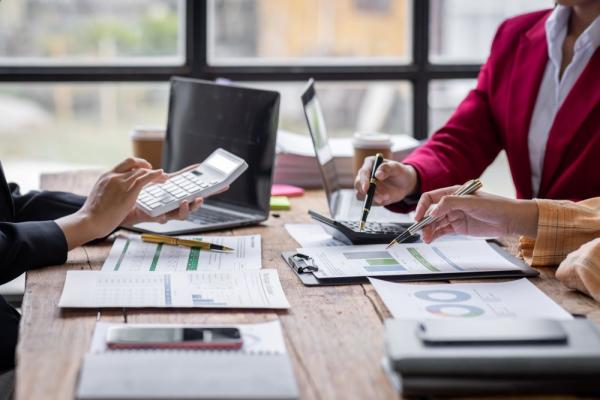 group-of-confident-business-people-point-to-graphs